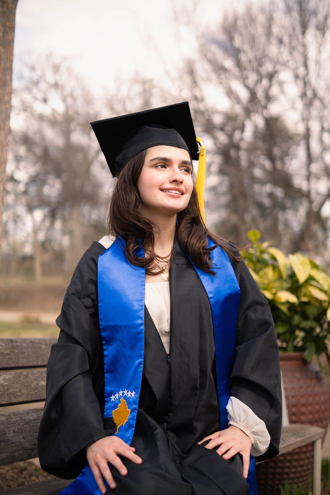 Texas A&M graduation portrait with Aggies pennant at stone building, DFW photographer